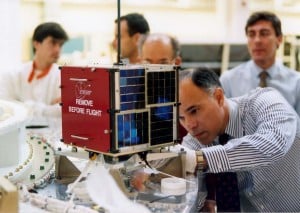 Prior to launch, Dr. Dino Lorenzini, KC4YMG, pPerforms a "fit check" on the "Eyesat" satellite that later became AMSAT-OSCAR 27 on orbit. Note the black and white paint on the spacecraft's antennas.