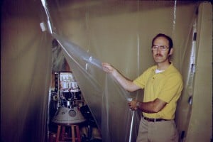 Dick Daniels, W4PUJ (SK), displays a partially assembled AMSAT-OSCAR 8 in his basement "clean room".