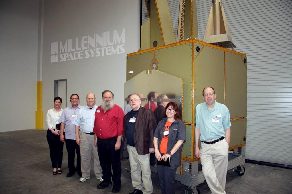 (L-R) Sonya Rowe, KK4NLO; Jerry Buxton, N0JY; Bob McGwier, N4HY; Franklin Antonio, N6NKF; Tom Clark, K3IO; Michelle Thompson, W5NYV; and Phil Karn, KA9Q standing next to the Aquila M8 Bus flight article. 